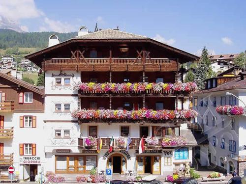 a large building with flower boxes on it at Post Hotel Moena in Moena