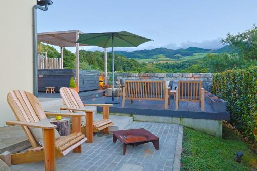 three chairs and a table with an umbrella on a patio at Assomada House in Nordeste
