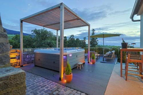 a hot tub on the deck of a house at Assomada House in Nordeste