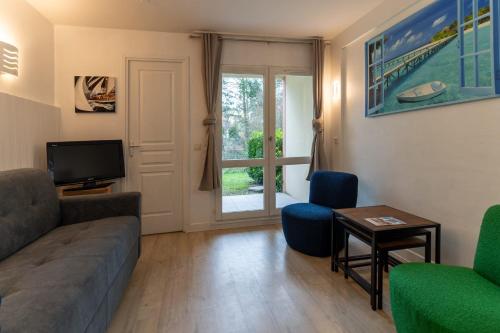 a living room with a couch and a tv at Appt rez de jardin 6 personnes avec piscine tennis et parking gratuit 21 in Le Touquet-Paris-Plage
