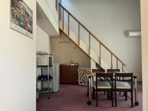 a dining room with a table and a staircase at 富士山サクラリゾート in Kai