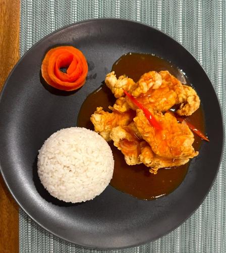 a plate of food with rice on a table at Villa Salama in Tanjung