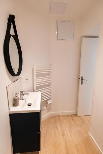 a bathroom with a sink and a mirror on the wall at - Apparts nets à prix honnête - in Brest