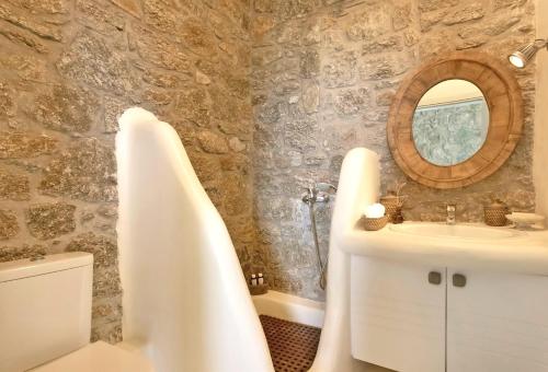 a bathroom with a tub and a sink and a mirror at Villa Ananda Mykonianvilla in Panormos Mykonos