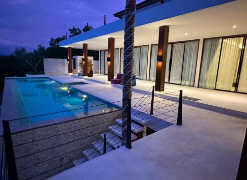 a villa with a swimming pool at night at Villa Salama in Tanjung