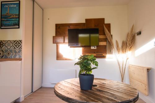 a room with a wooden table with a plant on it at - Apparts nets à prix honnête - in Brest