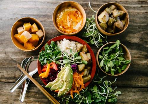 a table with a bowl of food and bowls of different foods at Byron Yoga Centre in Byron Bay