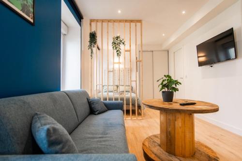 a living room with a couch and a table at - Apparts nets à prix honnête - in Brest