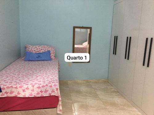 a small bedroom with a bed and a mirror at Casa luxo para a Cop 30 in Ananindeua