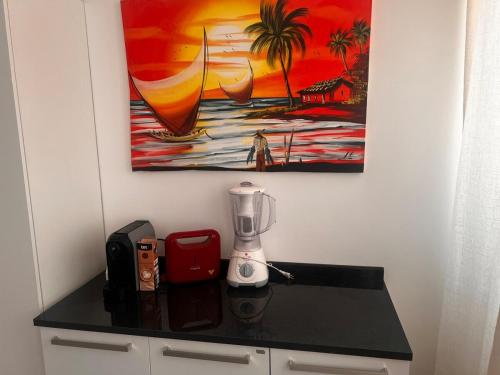a counter with a blender and a painting on the wall at Smart & Comfort 3 - Ap completo in João Pessoa