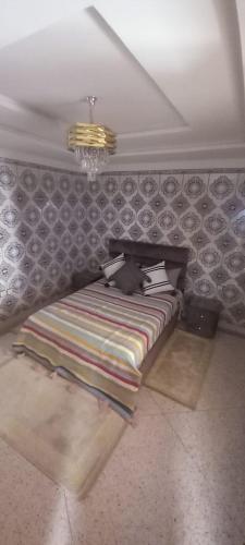 a bed in a room with a wall at Résidence chez Said in Sidi Ifni