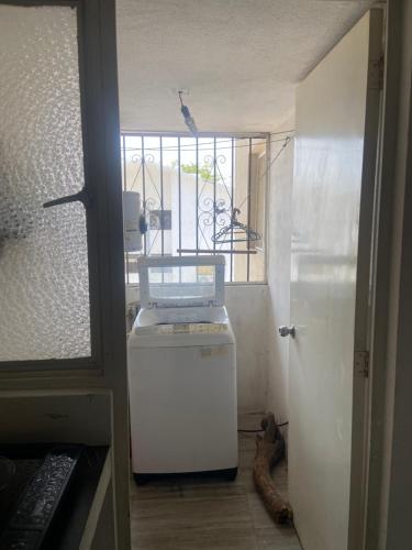 a room with a small refrigerator and a window at DEPA IXTLAN alberca y cerca de playa in Santa Cruz Huatulco