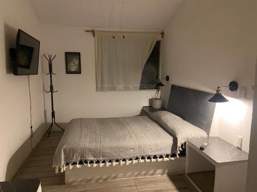a white bedroom with a bed and a window at DEPA IXTLAN alberca y cerca de playa in Santa Cruz Huatulco