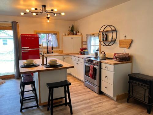 a kitchen with white cabinets and a red refrigerator at Bozeman Bungalow Downtown in Bozeman