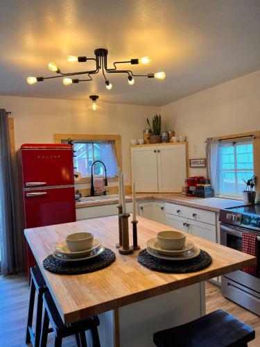 a kitchen with a wooden table and a red refrigerator at Bozeman Bungalow Downtown in Bozeman