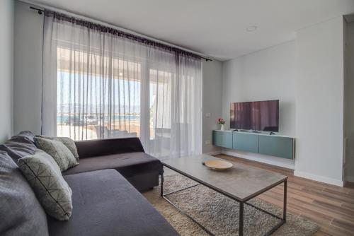 a living room with a couch and a table at Apartments by the sea Nin, Zadar - 23664 in Nin