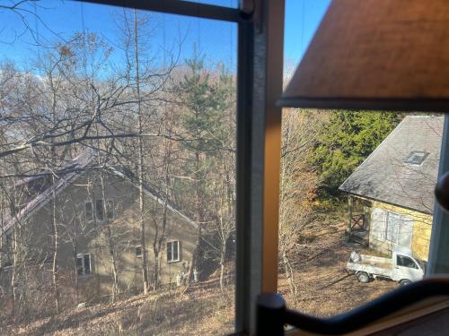 a window with a view of a house and a truck at 富士山サクラリゾート in Kai