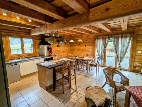 a kitchen and dining room with a table and chairs at Chalet tout confort en bois, Wifi, Animaux admis - FR-1-589-756 in Anould