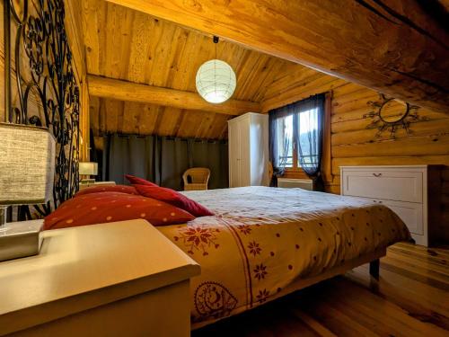 a bedroom with a bed in a wooden room at Chalet tout confort en bois, Wifi, Animaux admis - FR-1-589-756 in Anould
