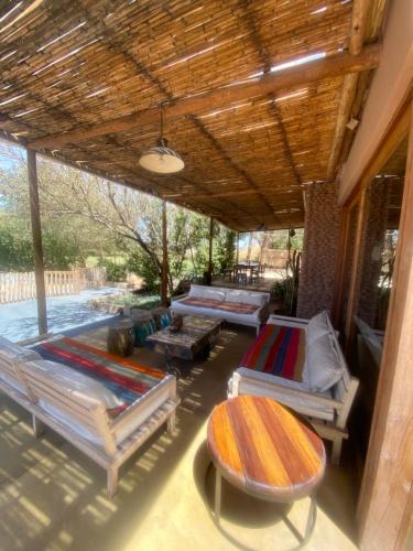 a patio with several surfboards and a table and benches at Casa Luna in San Pedro de Atacama