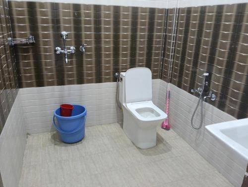 a bathroom with a toilet and a shower and a bucket at Monal Inn in Mīlam