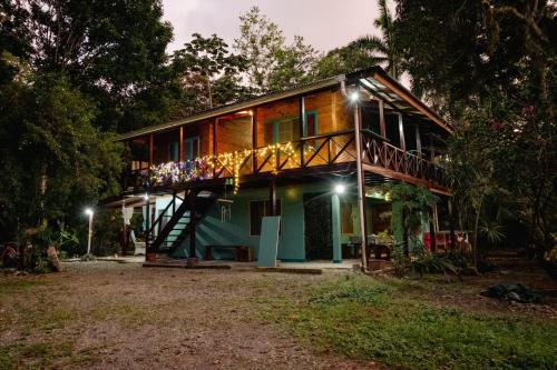 a house with a deck at night at Casa Aldirica in Cahuita
