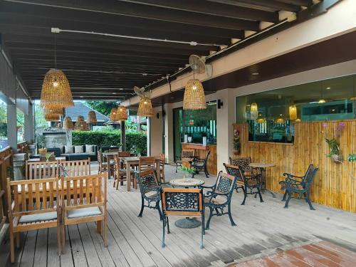 a patio with chairs and tables and a bar at Lanta Garden Hill Resort & Apartments in Ko Lanta