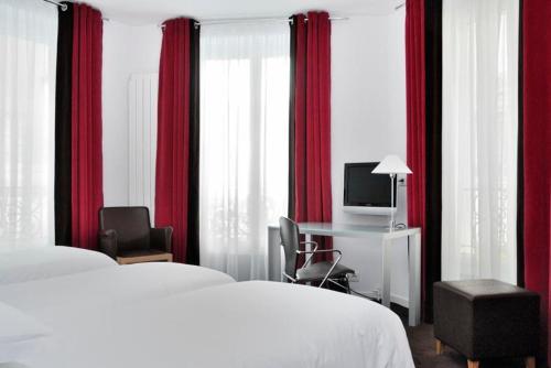 a hotel room with two beds and a desk with a television at Hôtel Albe Saint Michel in Paris