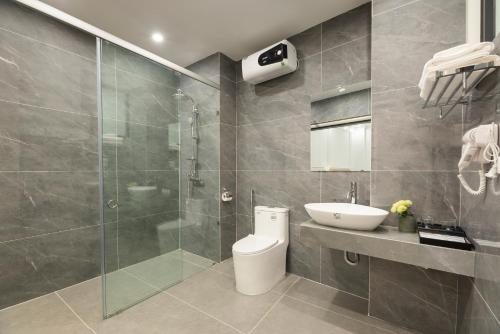 a bathroom with a toilet and a sink and a shower at Success Airport Hanoi Hotel in Phu Lo Dong