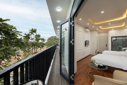 a bedroom with a balcony with a bed and a table at Success Airport Hanoi Hotel in Phu Lo Dong