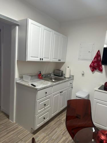 a kitchen with white cabinets and a sink at Villa Clara Red-Little Havana in Miami