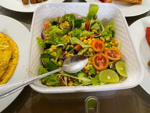 Hilltop Heaven في كاندي: سلطة في حاوية بلاستيكية مع ملعقة فيها