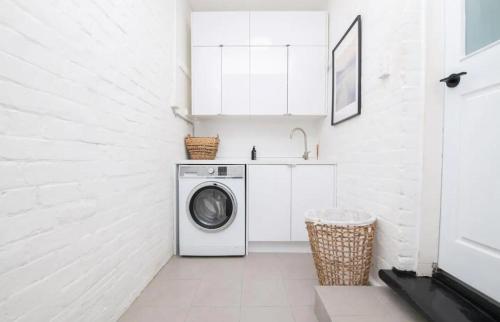 a white laundry room with a washing machine and a sink at The Paddington Bathurst #8 in Bathurst