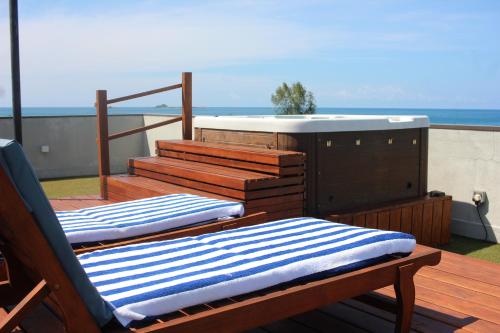two lounge chairs on a deck with a hot tub at Luxury penthouse , Nilaveli, Srilanka in Nilaveli