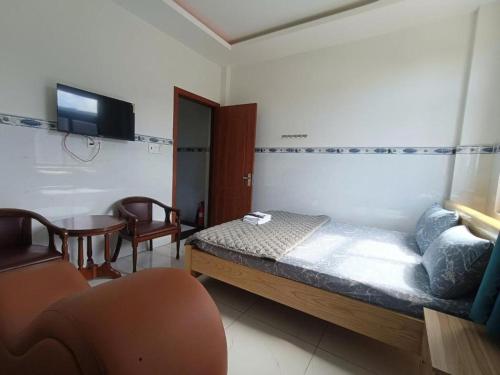 a bedroom with a bed and a table and a television at Phương Anh 2 - Hotel Bình Tân in Ho Chi Minh City