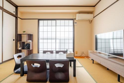 a dining room with a table and chairs and a large window at 最大5人で泊れる宿 新潟駅から徒歩7分 ペット同伴可 in Niigata