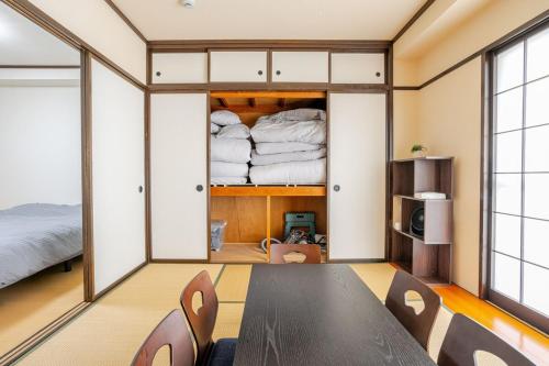 a room with a bed and a table and chairs at 最大5人で泊れる宿 新潟駅から徒歩7分 ペット同伴可 in Niigata