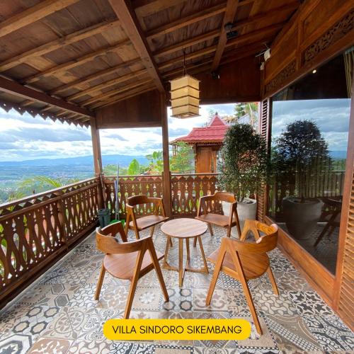a patio with chairs and a table on a balcony at Bagas Luxury Camp Telaga Menjer in Kejajar