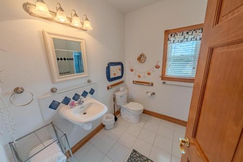 a bathroom with a sink and a toilet at Frolic Inn OBX - Semi Soundfront Retreat, Pool, Hot Tub, Boat Ramp, Elevator, Media & Game Room in Rodanthe
