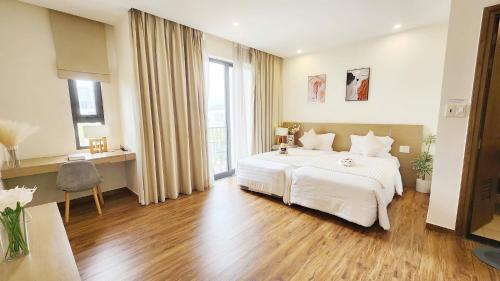 a bedroom with a large white bed and a desk at YLY Lotus in Ha Long