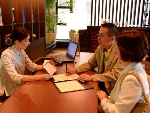 a man and woman sitting at a table with a laptop at The Moon Beach Museum Resort in Onna