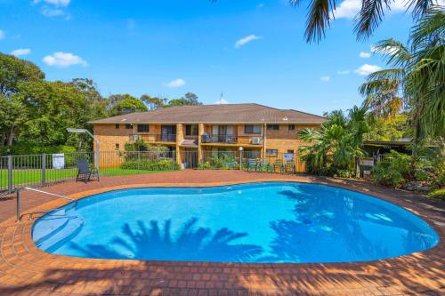 a large blue swimming pool in front of a house at Shelly Cove Apt 12 - common pool in Port Macquarie