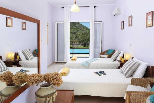 a bedroom with two beds and a large window at Villa Adonis in Halikounas