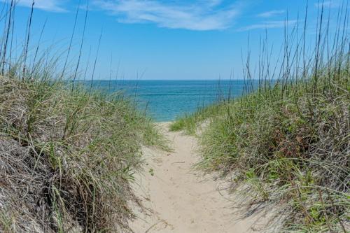 a path through the sand at the beach at Frolic Inn OBX - Semi Soundfront Retreat, Pool, Hot Tub, Boat Ramp, Elevator, Media & Game Room in Rodanthe