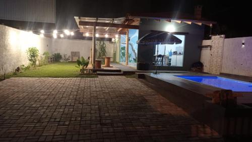 a house with a swimming pool at night at Casa Para temporada - casa ARASĒ in Bonito