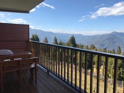 a balcony with a bench and a view of mountains at He Feng Homestay in Hualing