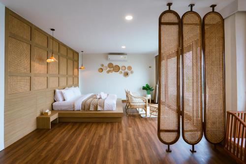 a bedroom with a bed and a room with wooden floors at เลอค่าดอยช้าง Le Quar Doi Chang Cafe Bistro Bed & Breakfast in Ban San Pu Loei