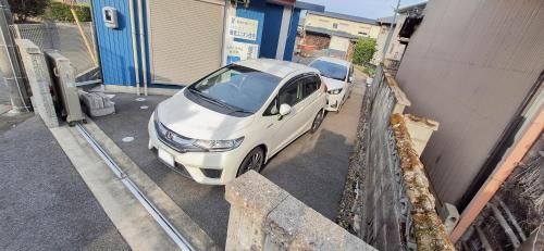 a white car parked in a parking lot next to a building at 茂平の宿 in Yoro