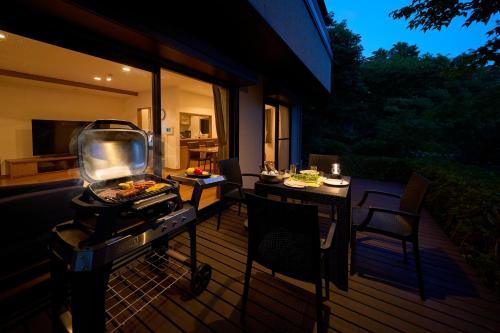 a grill on a deck with a table and chairs at Suite Villa Izukogen Prime in Ito