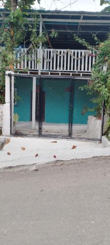 a gate on a sidewalk in front of a building at Hospedaje y jardín botánico in El Remate